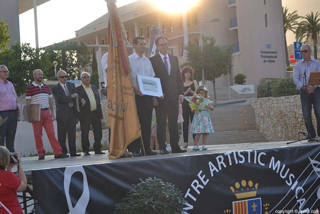 El presidente de la Banda de Música de la Rectoría recibiendo un agradecimiento