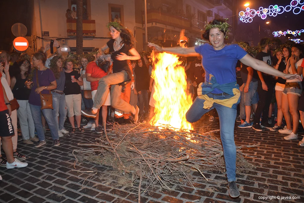 Dos atrevidas chicas saltando la hoguera