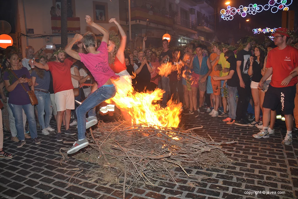 Un dúo saltando la hoguera