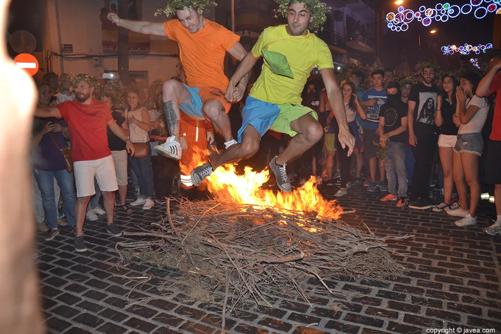 Un par de chicos saltando la hoguera