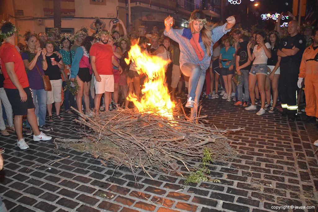 Una guapa saltando la hoguera