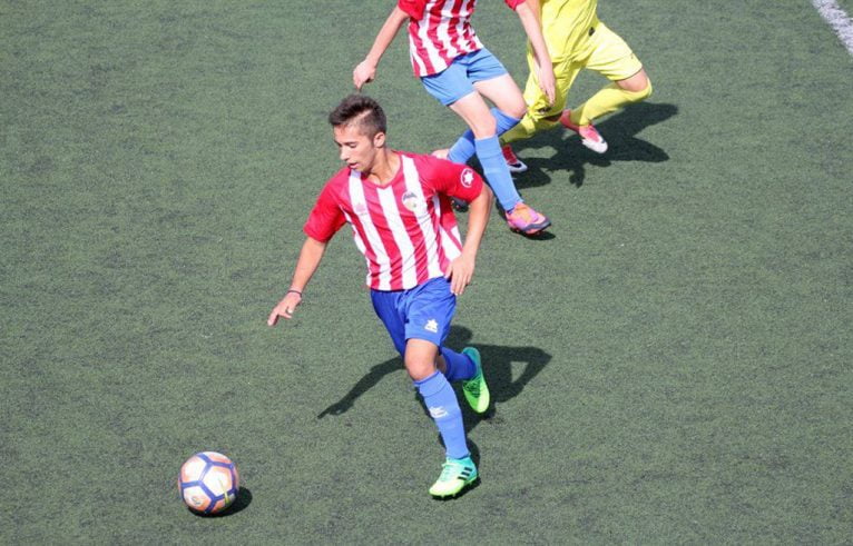 Jugador del juvenil del CD Jávea conduciendo la pelota