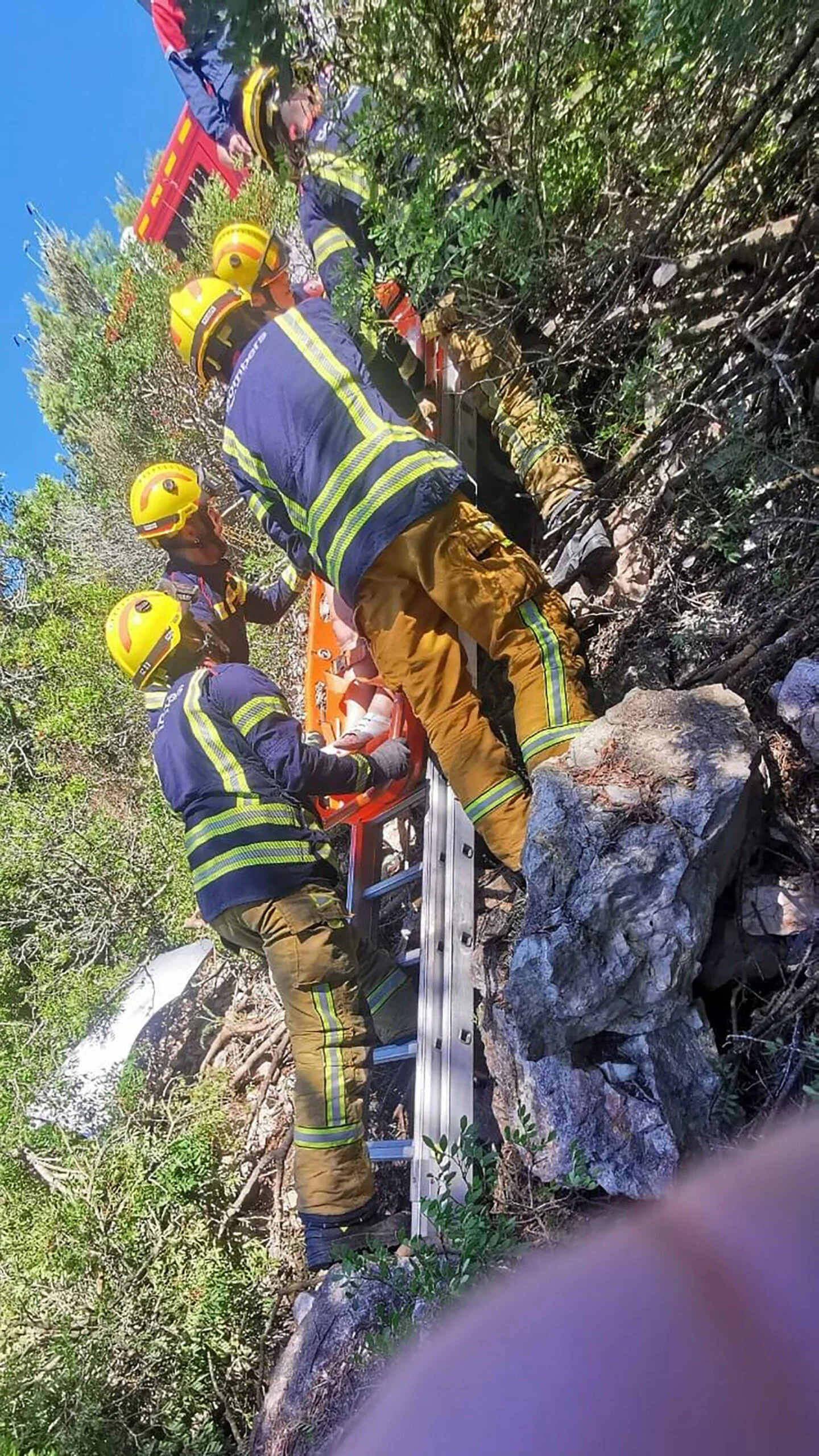 Los medios de rescate subiendo a la mujer en camilla