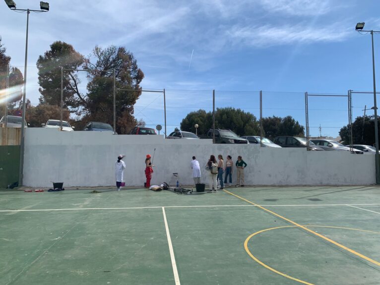 Lucia junto a los alumnos del IES Antoni Llidó preparan la pared para plasmar el mural