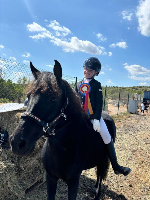 Imagen: Olivia junto a su caballo y la medalla