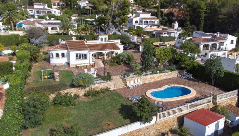 Piscina rodeada de césped y zona de solarium