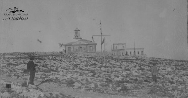 Imagen: Foto antigua en la que se aprecia el ondeo de banderas con el edificio del Semáforo a la derecha y un hombre en el mastil