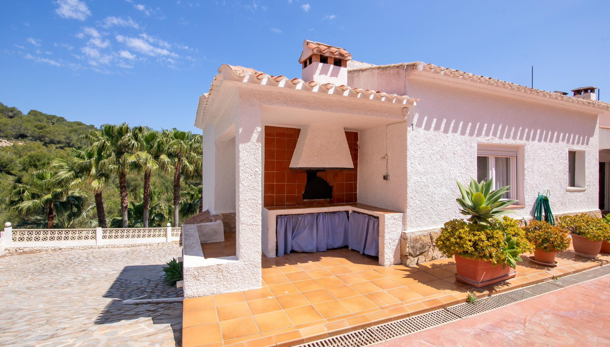 Terraza con comedor exterior y horno de leña